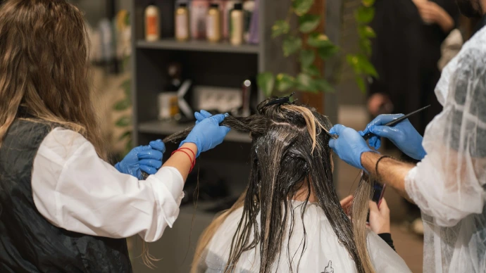 a woman getting her hair done by a hair stylist
